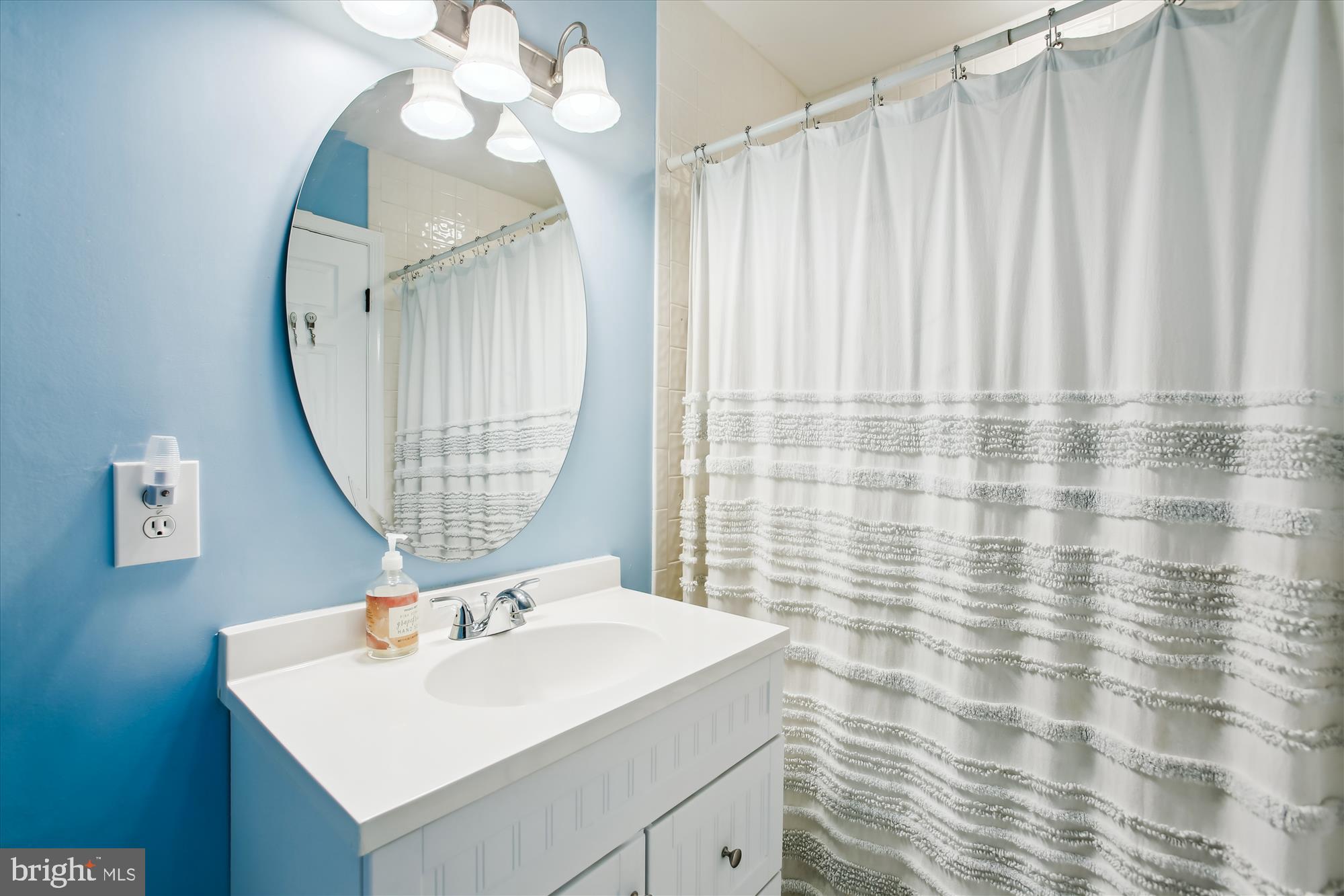 8231 Crown Court Road Alexandria, VA 22308 - Photo 25 of 33 a bathroom with a sink a mirror and a shower curtain