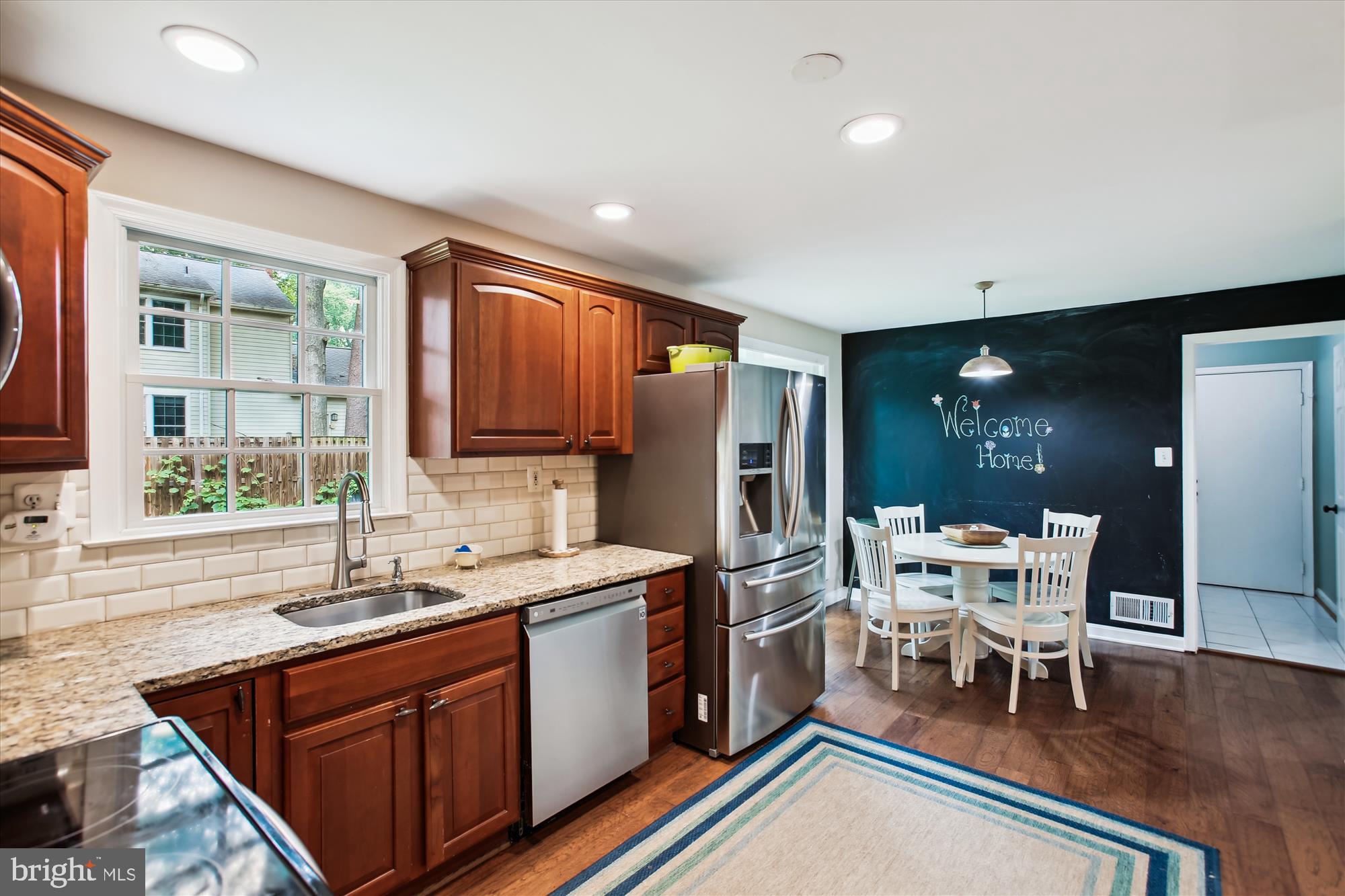 8231 Crown Court Road Alexandria, VA 22308 - Photo 9 of 33 a kitchen with stainless steel appliances granite countertop a table chairs and a sink
