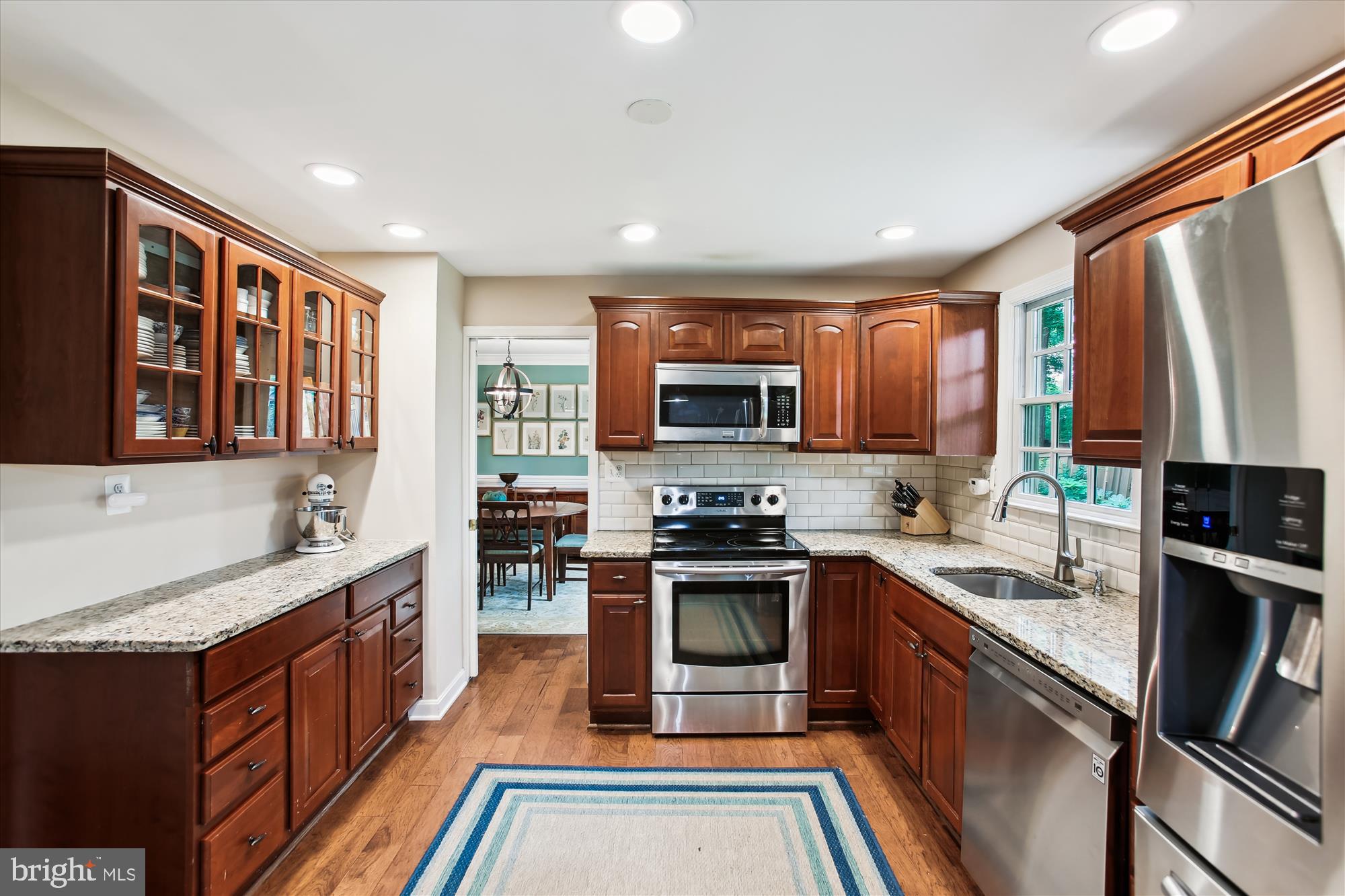 8231 Crown Court Road Alexandria, VA 22308 - Photo 10 of 33 a kitchen with stainless steel appliances granite countertop a stove top oven a sink dishwasher a refrigerator and a oven with wooden cabinets