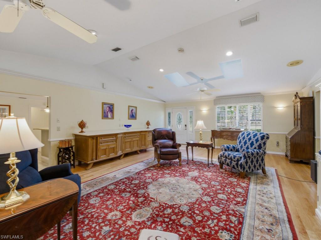 6840 Sable Ridge Lane Naples, FL 34109 - Photo 15 of 38 Living room featuring lofted ceiling, a ceiling fan, light wood-style floors, and ornamental molding