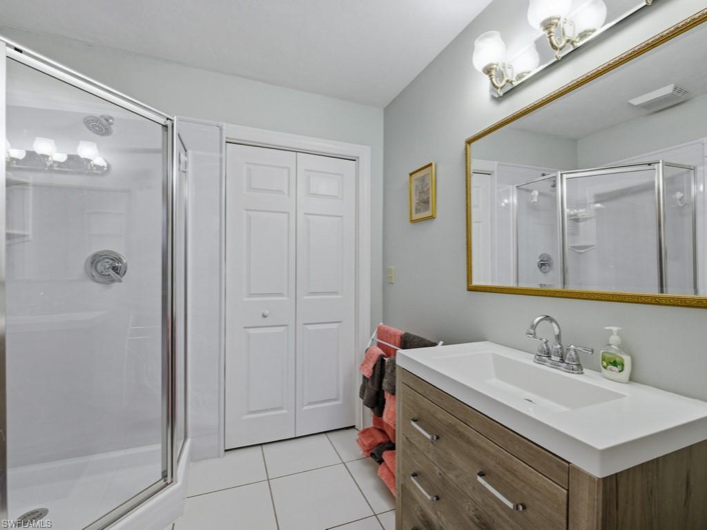 6840 Sable Ridge Lane Naples, FL 34109 - Photo 24 of 38 Full bath with a stall shower, a closet, vanity, and light tile patterned flooring
