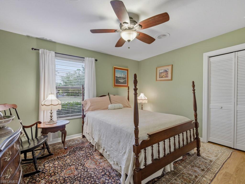 6840 Sable Ridge Lane Naples, FL 34109 - Photo 26 of 38 Bedroom 3 featuring a closet, ceiling fan, and wood finished floors