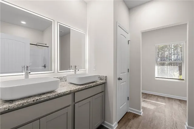 a bathroom with a granite countertop sink and a mirror