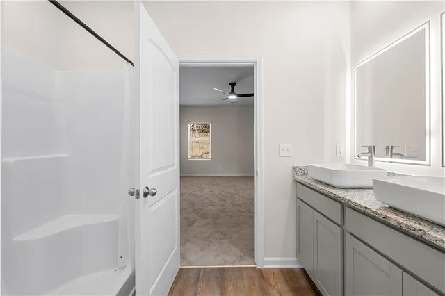a bathroom with a granite countertop sink a mirror and a bathtub