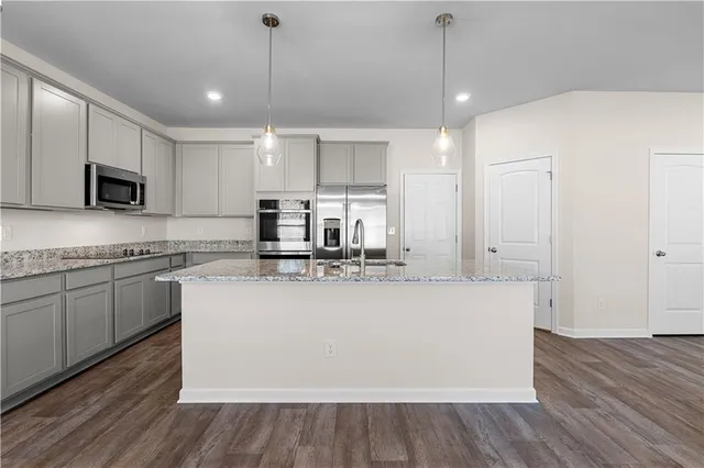 a kitchen with kitchen island a sink and a stove top oven