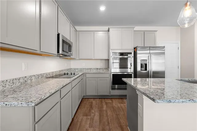 a kitchen with stainless steel appliances granite countertop a sink stove and refrigerator
