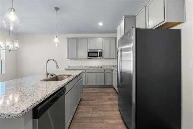 a kitchen with stainless steel appliances granite countertop a sink stove and refrigerator