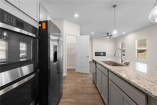 a kitchen with stainless steel appliances granite countertop a sink and refrigerator