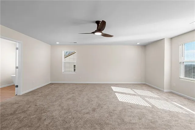 an empty room with windows and cabinet