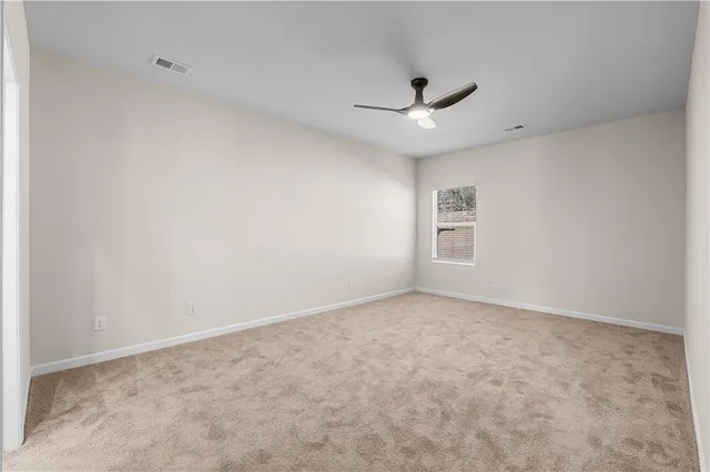 an empty room with a ceiling fan and a window