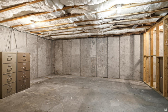 1089 West 2325th Street North Layton, UT 84041 - Photo 34 of 40 Unfinished basement space featuring exposed ceiling joists with insulation, concrete slab flooring, and concrete foundation walls
