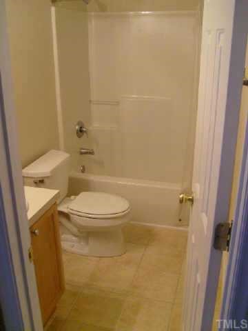 2352 Persimmon Ridge Drive Raleigh, NC 27604 - Photo 7 of 12 a white toilet sitting next to a bath tub