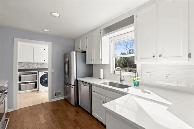 a kitchen with a refrigerator sink and cabinets