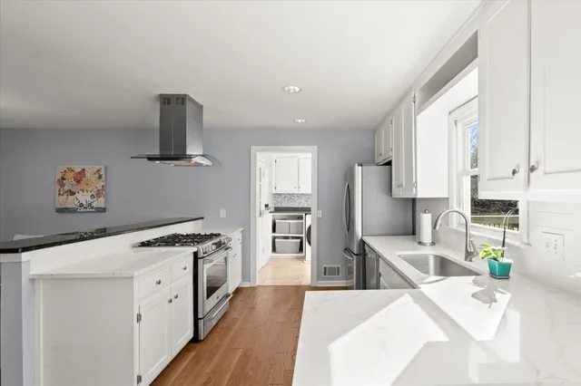 a kitchen with stainless steel appliances granite countertop a sink stove and refrigerator