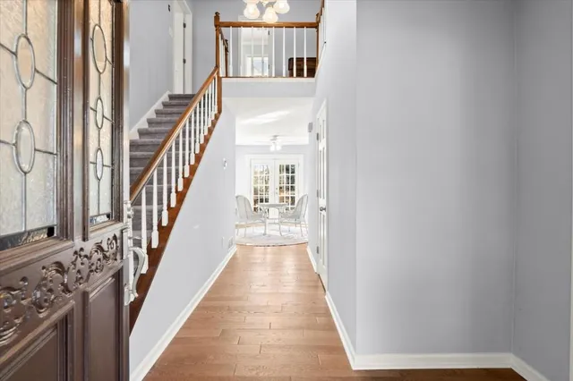 a view of a hallway with wooden floor and staircase