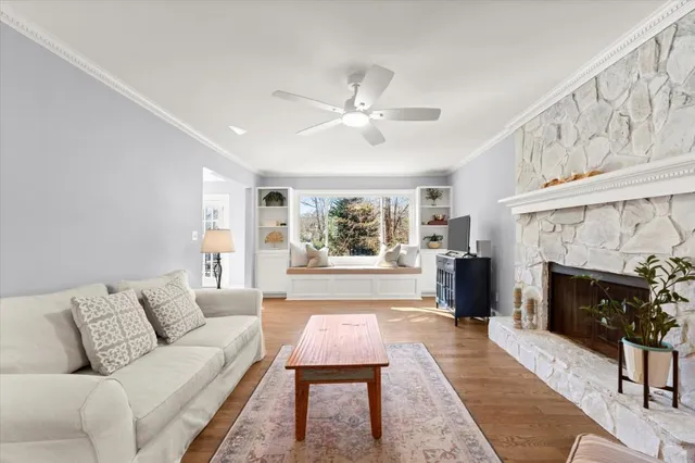 a living room with furniture a fireplace and a large window