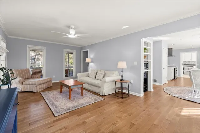 a living room with furniture and a wooden floor
