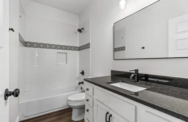 a bathroom with a double vanity sink toilet mirror and shower