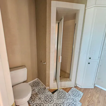 a bathroom with a granite countertop sink a mirror and a shower