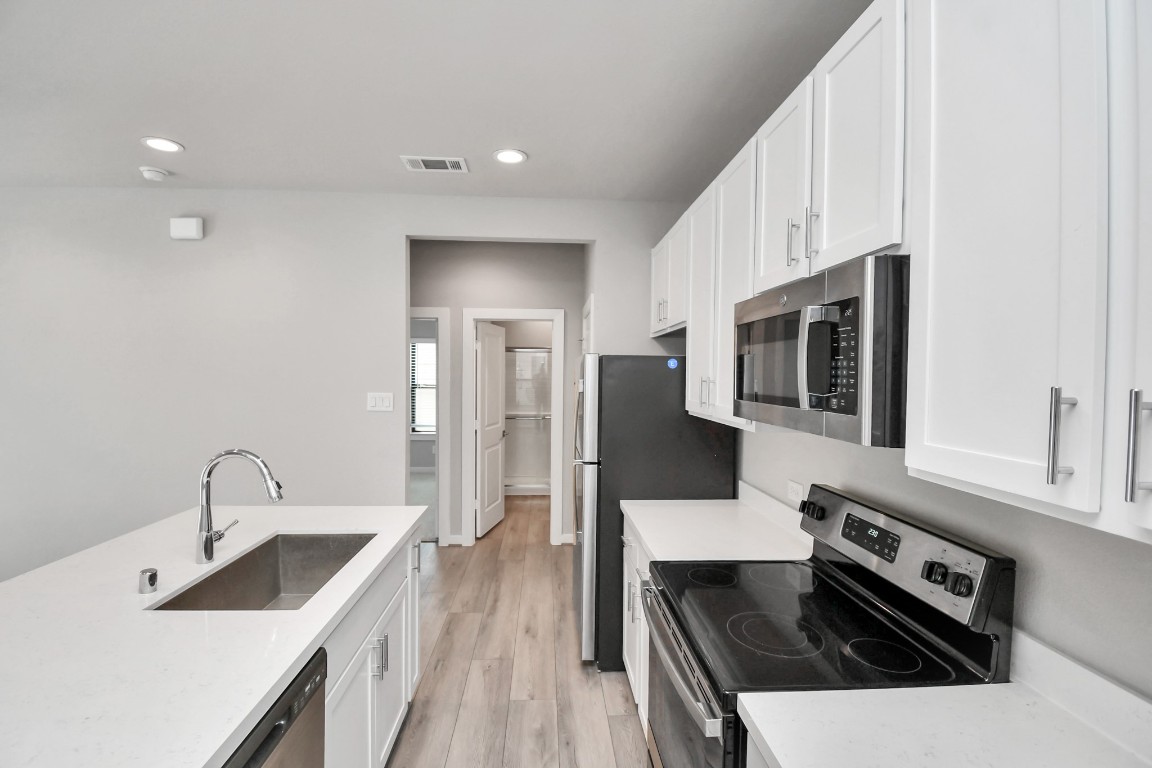 23823 Cumberland Ridge Drive, Unit 515 Hockley, TX 77447 - Photo 8 of 29 a kitchen with stainless steel appliances a sink a stove and a microwave