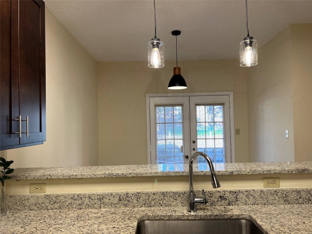 a view of a kitchen with a sink and chandelier