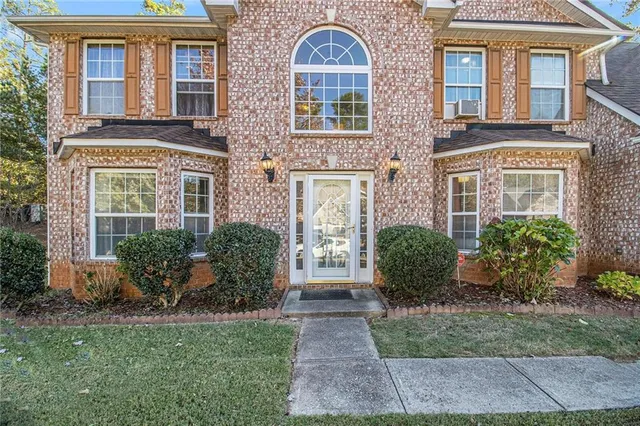 front view of a brick house with a yard