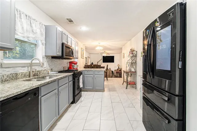 a kitchen with kitchen island granite countertop a sink counter top space appliances and a window