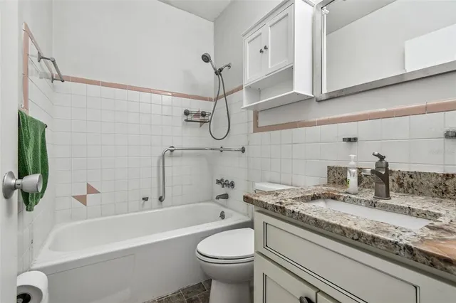 a bathroom with a granite countertop toilet sink and mirror