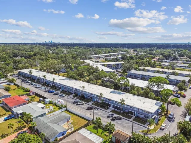aerial view of multi story residential apartment building with yard