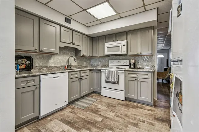 a kitchen with white cabinets and white appliances