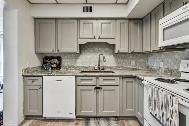 a kitchen with granite countertop wooden cabinets and a sink