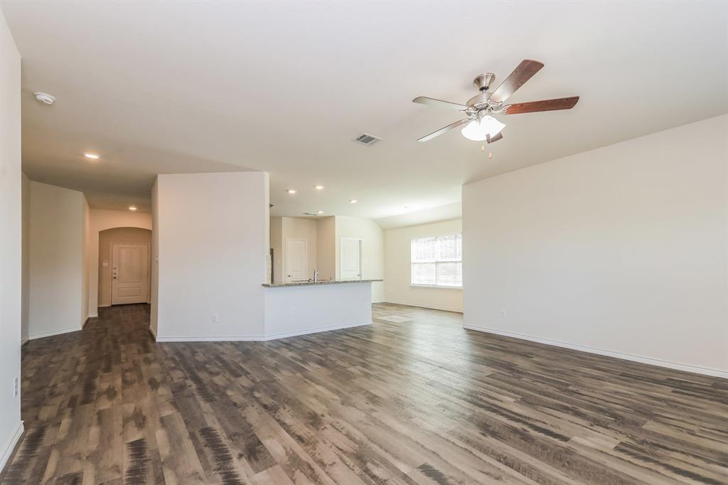 574 Kara Drive Fate, TX 75087 - Photo 4 of 15 a view of an empty room with wooden floor and a ceiling fan