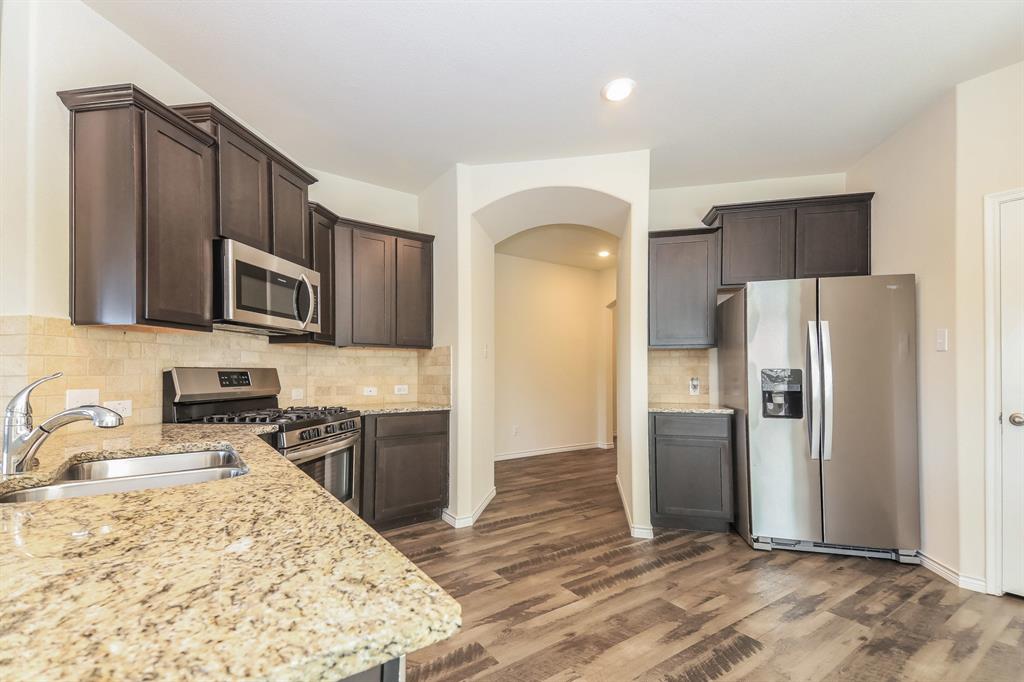 574 Kara Drive Fate, TX 75087 - Photo 6 of 15 a kitchen with stainless steel appliances granite countertop a refrigerator stove and oven