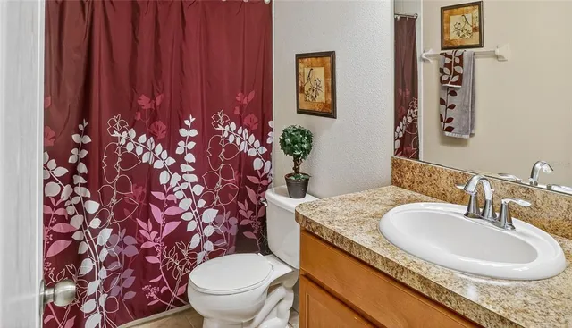 a bathroom with a granite countertop sink toilet and shower