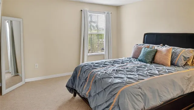 a bed sitting in a bedroom next to a window