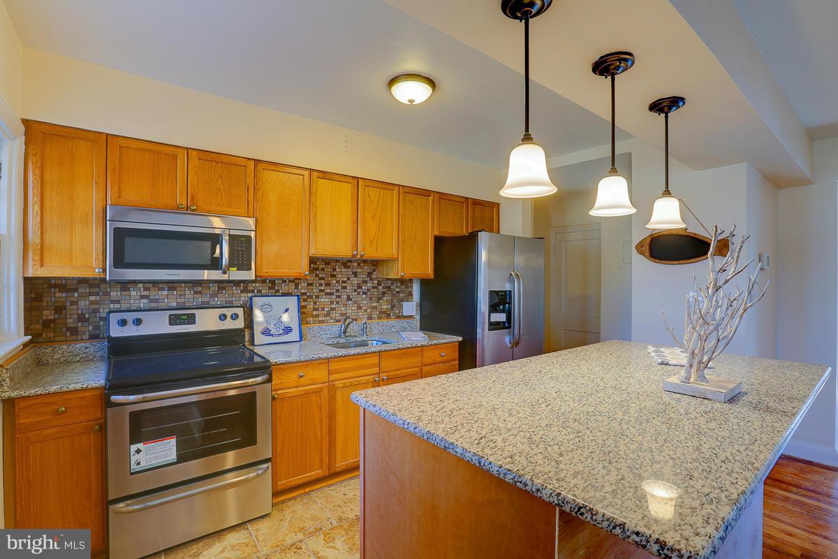 1434 Stonewood Road Baltimore, MD 21239 - Photo 14 of 28 a kitchen with stainless steel appliances granite countertop a sink a oven and a wooden floor
