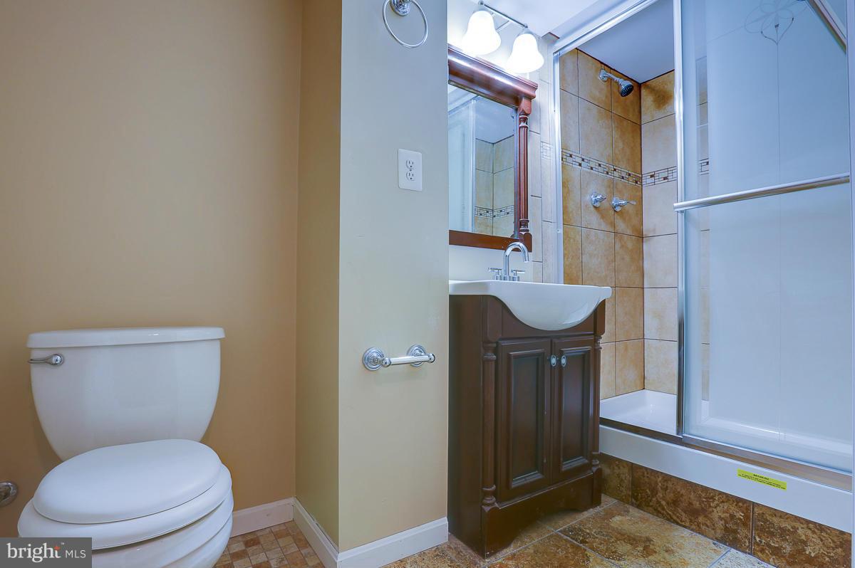 1434 Stonewood Road Baltimore, MD 21239 - Photo 22 of 28 a bathroom with a toilet a sink and mirror