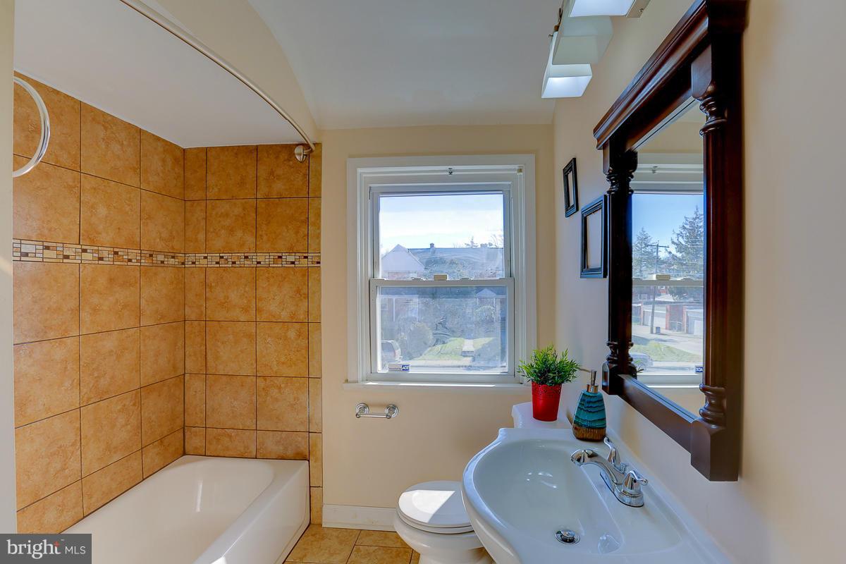 1434 Stonewood Road Baltimore, MD 21239 - Photo 23 of 28 a bathroom with a sink toilet and shower