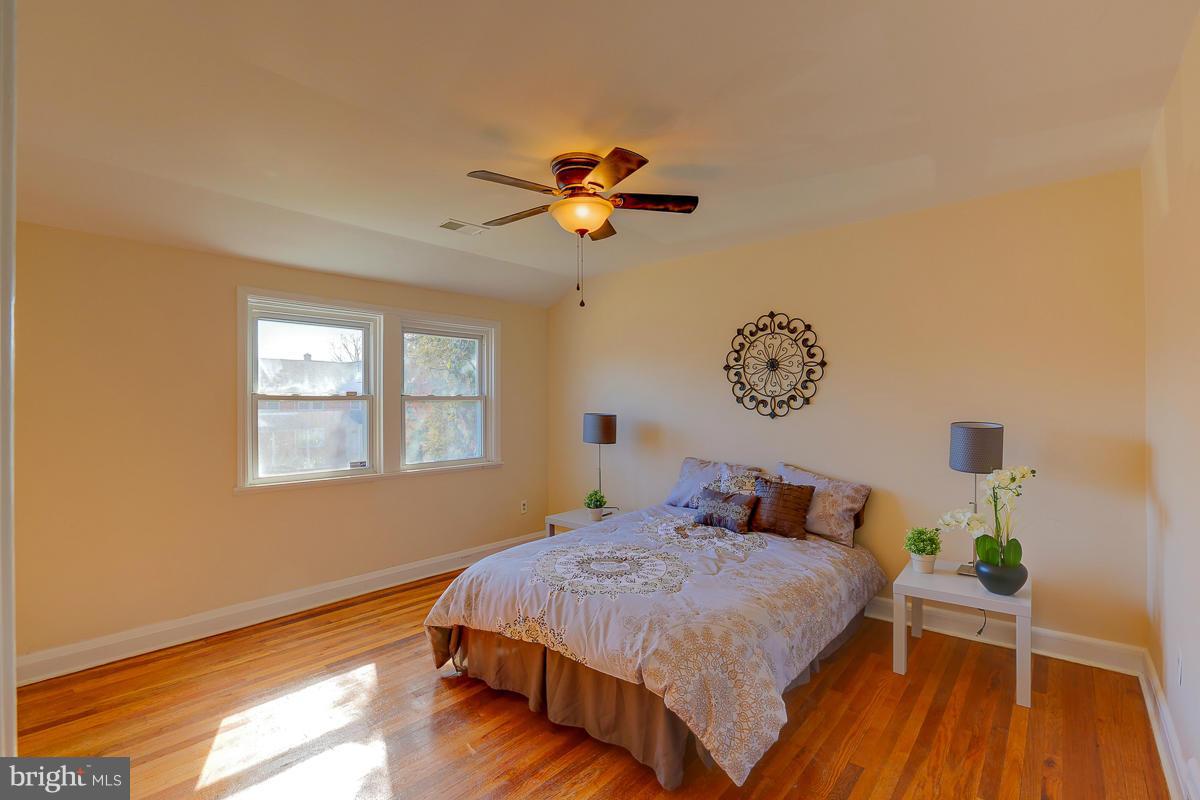 1434 Stonewood Road Baltimore, MD 21239 - Photo 25 of 28 a bedroom with a bed and wooden floor