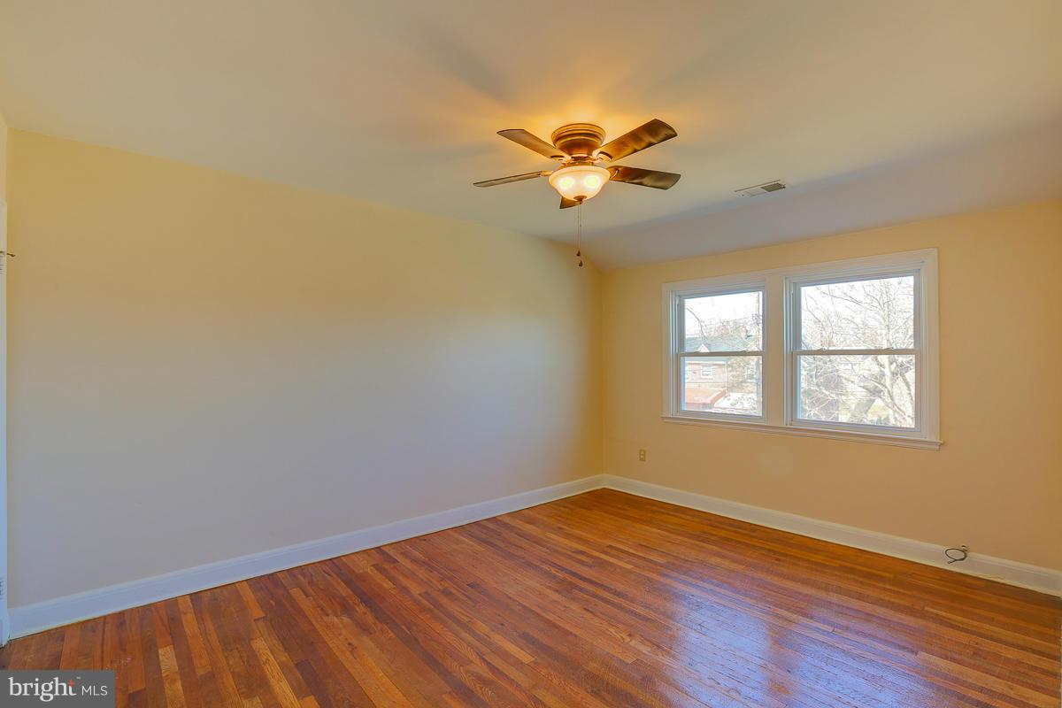 1434 Stonewood Road Baltimore, MD 21239 - Photo 27 of 28 a view of an empty room with wooden floor and a window
