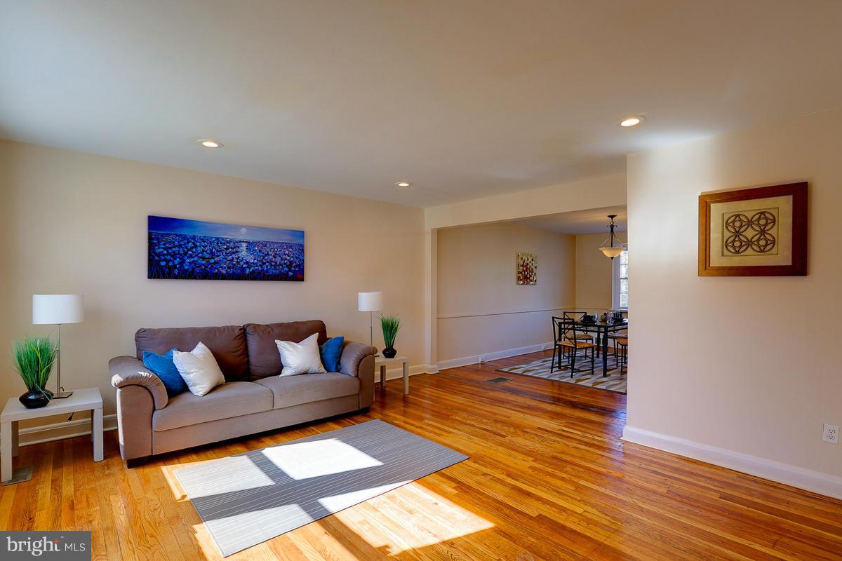 1434 Stonewood Road Baltimore, MD 21239 - Photo 4 of 28 a living room with furniture and a dining table with wooden floor
