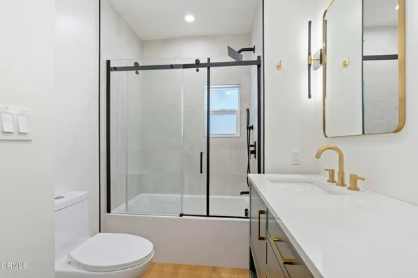 a bathroom with a granite countertop sink toilet and shower
