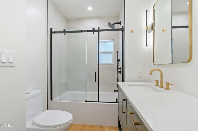 a bathroom with a granite countertop sink toilet and shower