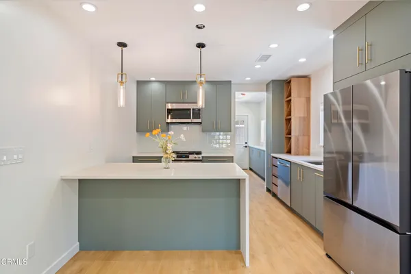 a kitchen with kitchen island a counter top space stainless steel appliances and cabinets