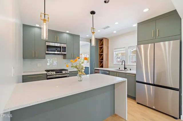 a kitchen with stainless steel appliances a refrigerator sink and microwave
