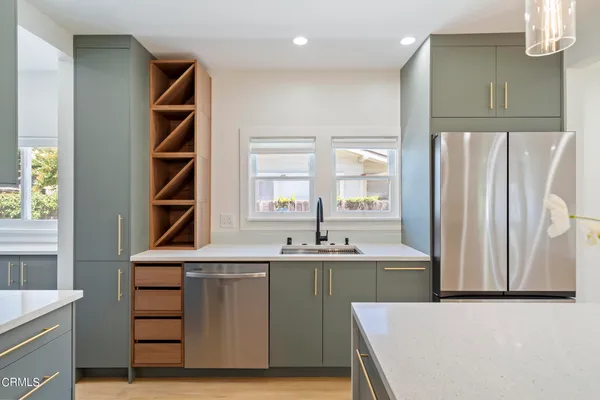 a kitchen with kitchen island a sink stainless steel appliances and cabinets