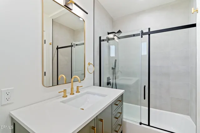 a bathroom with a sink vanity and shower