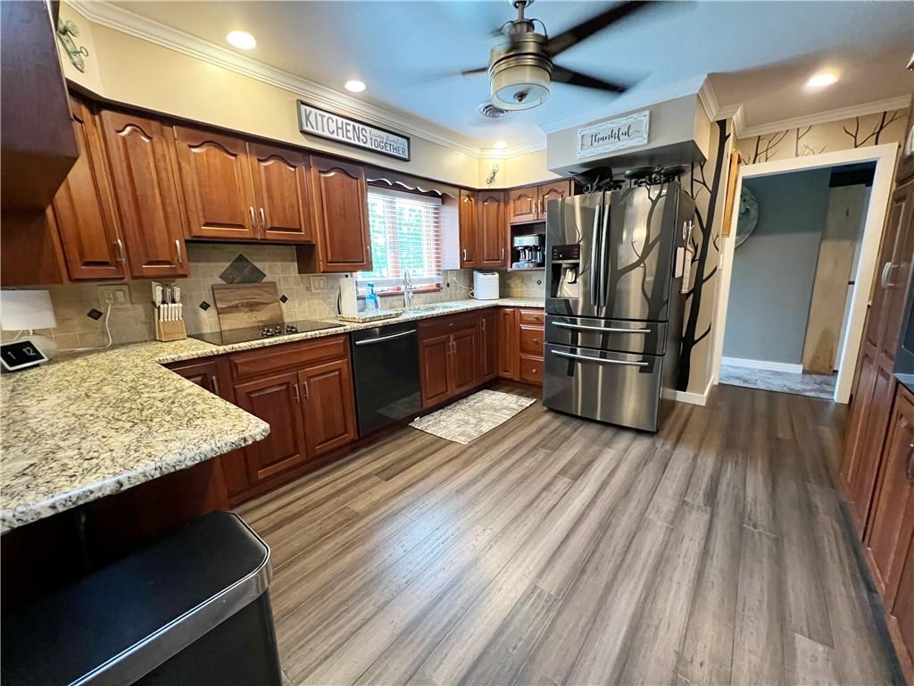 92 Blom Road Grove City, PA 16127 - Photo 16 of 28 a kitchen with stainless steel appliances granite countertop a refrigerator a sink dishwasher a stove and white countertops with wooden floor