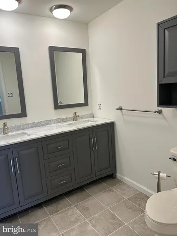a bathroom with a double vanity sink and a mirror