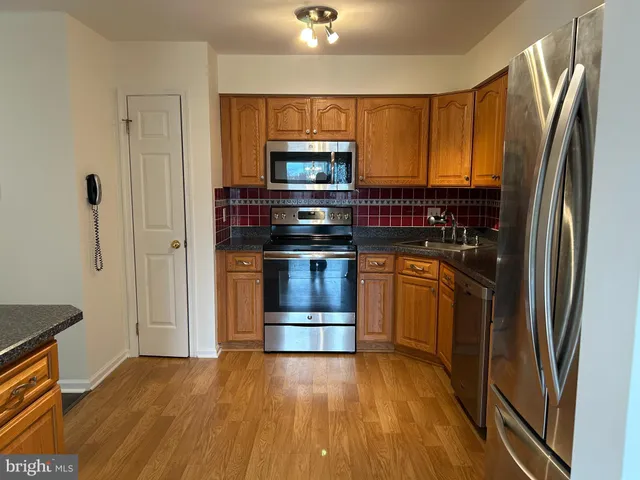 a kitchen with stainless steel appliances granite countertop a refrigerator stove and sink